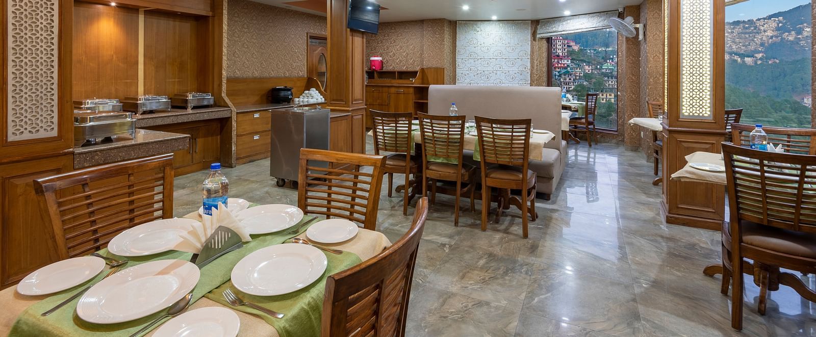 Dining area with a table set for a meal, featuring chairs and plates neatly arranged on the table at DLS Hotels The Rock Castle.
